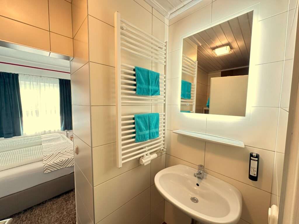 Badezimmer von Appartement mit Handtuchwärmern und blauen Handtüchern