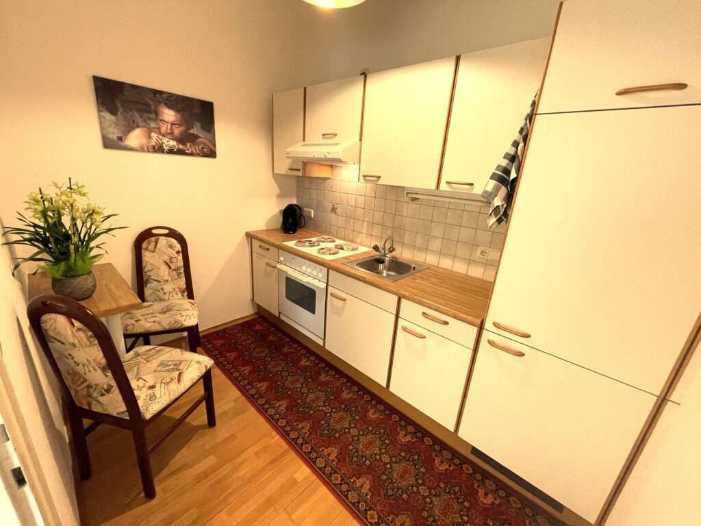 Küche mit Essecke, Grünpflanze und Terrence Hill Bidl an der Wand