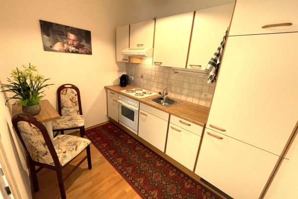 Küche mit Essecke, Grünpflanze und Terrence Hill Bidl an der Wand